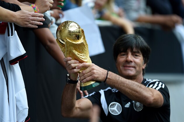 Germany's head coach Joachim Loew shows the world cup trophy during a public training session of the German national football team in Duesseldorf, Germany on September 1, 2014. Germany's squad prepares for the upcoming friendly game against Argentina on September 3, 2014 in Duesseldorf. AFP PHOTO / PATRIK STOLLARZ        (Photo credit should read PATRIK STOLLARZ/AFP/Getty Images)