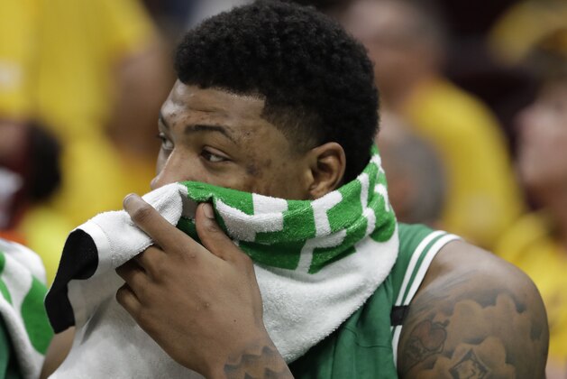 Boston Celtics' Marcus Smart wipes his face as he sits on the bench in the second half of Game 3 of the NBA basketball Eastern Conference finals against the Cleveland Cavaliers, Saturday, May 19, 2018, in Cleveland. (AP Photo/Tony Dejak)