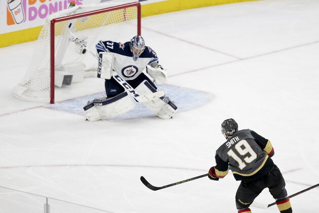 Vegas Golden Knights right wing Reilly Smith scores past Winnipeg Jets goaltender Connor Hellebuyck during the third period of Game 4 of the NHL hockey Western Conference finals Friday, May 18, 2018, in Las Vegas. (AP Photo/Marc Sanchez)