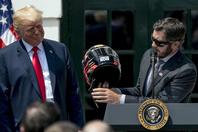 President Donald Trump reacts as 2017 NASCAR Cup champion Martin Truex Jr., right, presents him with a racing helmet during a ceremony for Truex and his racing team on the South Lawn of the White House in Washington, Monday, May 21, 2018. (AP Photo/Andrew Harnik)
