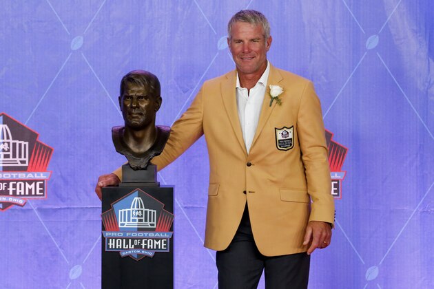 Former NFL player Brett Favre poses with a bust of himself during an induction ceremony at the Pro Football Hall of Fame Saturday, Aug. 6, 2016, in Canton, Ohio. (AP Photo/Gene J. Puskar)