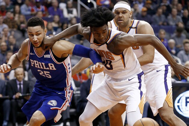 Phoenix Suns forward Josh Jackson, front right, battles with Philadelphia 76ers guard Ben Simmons (25) for a loose ball as Suns forward Jared Dudley, back right, watches during the first half of an NBA basketball game Sunday, Dec. 31, 2017, in Phoenix. (AP Photo/Ross D. Franklin)
