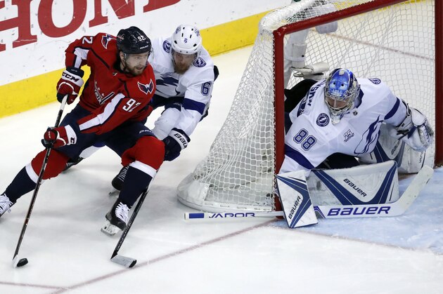 Washington Capitals center Evgeny Kuznetsov (92), from Russia, skates with the puck with Tampa Bay Lightning defenseman Anton Stralman (6), from Sweden, behind him with Tampa Bay Lightning goaltender Andrei Vasilevskiy (88), from Russia, in goal during the second period of Game 6 of the NHL Eastern Conference finals hockey playoff series, Monday, May 21, 2018, in Washington. (AP Photo/Alex Brandon)