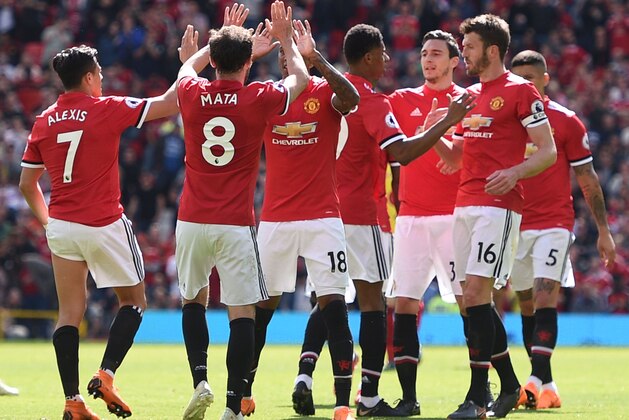 Manchester United's English striker Marcus Rashford (C) celebrates with teammates after scoring the opening goal during the English Premier League football match between Manchester United and Watford at Old Trafford in Manchester, north west England, on May 13, 2018. (Photo by Oli SCARFF / AFP) / RESTRICTED TO EDITORIAL USE. No use with unauthorized audio, video, data, fixture lists, club/league logos or 'live' services. Online in-match use limited to 75 images, no video emulation. No use in betting, games or single club/league/player publications. /         (Photo credit should read OLI SCARFF/AFP/Getty Images)