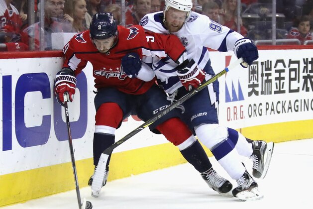WASHINGTON, DC - MAY 15:  Steven Stamkos #91 of the Tampa Bay Lightning hits Dmitry Orlov #9 of the Washington Capitals in Game Three of the Eastern Conference Finals during the 2018 NHL Stanley Cup Playoffs at the Capital One Arena on May 15, 2018 in Washington, DC. The Lightning defeated the Capitals 4-2.  (Photo by Bruce Bennett/Getty Images)