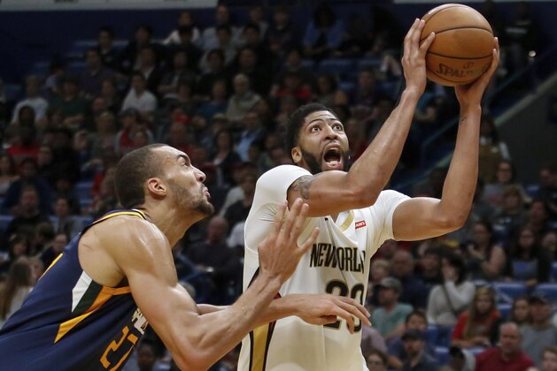 New Orleans Pelicans forward Anthony Davis (23) shoots against Utah Jazz center Rudy Gobert (27) in the first half of an NBA basketball game in New Orleans, Sunday, March 11, 2018. (AP Photo/Scott Threlkeld)