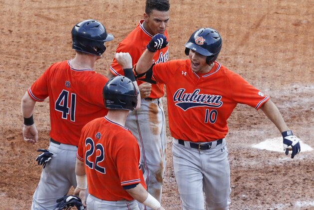 Auburn infielder Edouard Julien (10) celebrates with Steven Williams (41), Brett Wright (22), and Will Holland (17) after he hit a grand run during the seventh inning of a Southeastern Conference tournament NCAA college baseball game against Mississippi, Wednesday, May 23, 2018, in Hoover, Ala. (AP Photo/Butch Dill)