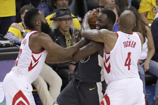 Golden State Warriors forward Draymond Green, center, is defended by Houston Rockets guard James Harden, left, and forward P.J. Tucker (4) during the second half of Game 4 of the NBA basketball Western Conference Finals in Oakland, Calif., Tuesday, May 22, 2018. (AP Photo/Jeff Chiu)