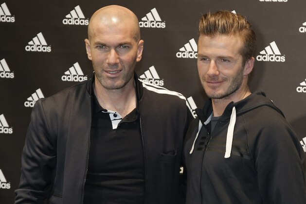 Soccer legend Zinedine Zidane, left, and Paris Saint Germain's David Beckham pose for a photograph, during a media event, in a sports store, on the Champs Elysees Avenue, in Paris, Thursday, Feb. 28, 2013. (AP Photo/Francois Mori)