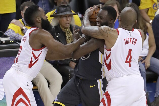 Golden State Warriors forward Draymond Green, center, is defended by Houston Rockets guard James Harden, left, and forward P.J. Tucker (4) during the second half of Game 4 of the NBA basketball Western Conference Finals in Oakland, Calif., Tuesday, May 22, 2018. (AP Photo/Jeff Chiu)