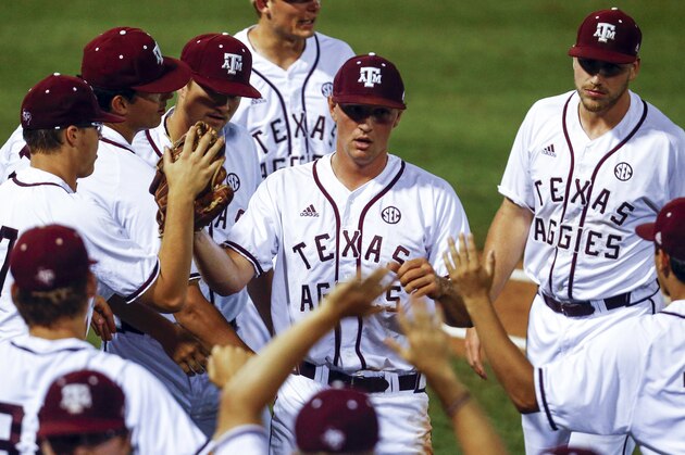 Texas A&M pitcher John Doxakis (14) is congratulated by teammates as he walks off the field during the third inning of a Southeastern Conference tournament NCAA college baseball game against Auburn, Thursday, May 24, 2018, in Hoover, Ala. (AP Photo/Butch Dill)