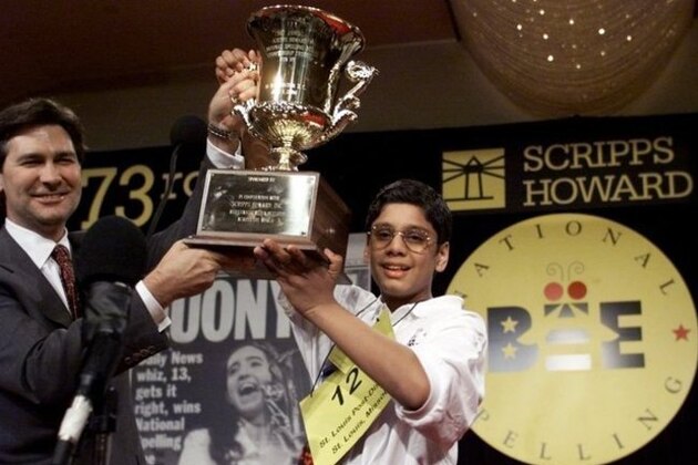 FILE - In this  June 1, 2000, file photo, George Abraham Thampy, 12, right, of Maryland Heights, Mo. is presented with the National Spelling Bee trophy by Scripps-Howard President and Chief Executive Officer Kenneth Lowe.  Thampy correctly spelled