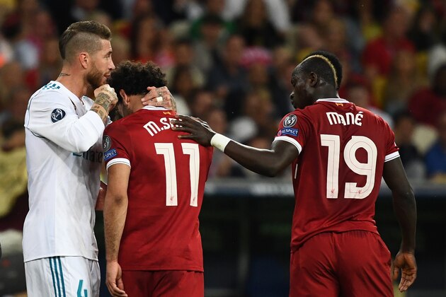 Liverpool's Egyptian forward Mohamed Salah (C) reacts as he leaves the pitch after an injury while Liverpool's Senegalese midfielder Sadio Mane (R) and Real Madrid's Spanish defender Sergio Ramos (L) comforts him  during the UEFA Champions League final football match between Liverpool and Real Madrid at the Olympic Stadium in Kiev, Ukraine, on May 26, 2018. (Photo by FRANCK FIFE / AFP)        (Photo credit should read FRANCK FIFE/AFP/Getty Images)