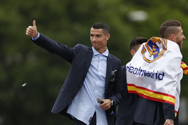 Real Madrid's Cristiano Ronaldo gestures to supporters as he celebrates with teammates after winning the Champions League final soccer match, at the Cibeles square in Madrid, Spain, Sunday, May 27, 2018. (AP Photo/Francisco Seco)