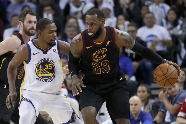 Cleveland Cavaliers forward LeBron James (23) moves the ball around Golden State Warriors forward Kevin Durant (35) during the second half of an NBA basketball game in Oakland, Calif., Monday, Dec. 25, 2017. The Warriors won 99-92. (AP Photo/Tony Avelar)