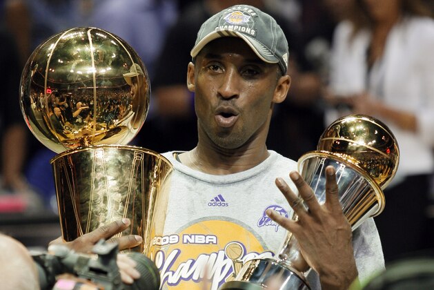 Los Angeles Lakers' Kobe Bryant holds the Larry O'Brien championship trophy and finals MVP trophy after the Lakers beat the Orlando Magic 99-86 in Game 5 of the NBA basketball finals Sunday, June 14, 2009, in Orlando, Fla. (AP Photo/David J. Phillip)