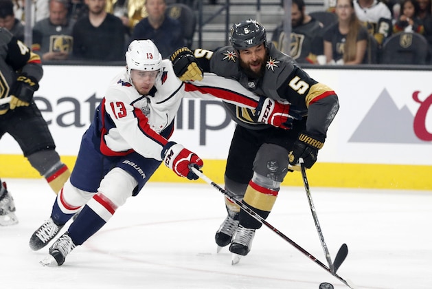 Washington Capitals left wing Jakub Vrana, left, of the Czech Republic, battles for the puck with Vegas Golden Knights defenseman Deryk Engelland during first period in Game 1 of the NHL hockey Stanley Cup Finals Monday, May 28, 2018, in Las Vegas. (AP Photo/John Locher)
