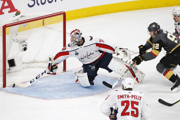 Washington Capitals goaltender Braden Holtby, left, stops a shot by Vegas Golden Knights left wing Tomas Nosek, second from right, of the Czech Republic, as defenseman Dmitry Orlov, right, of Russia, and right wing Devante Smith-Pelly defend during the second period in Game 1 of the NHL hockey Stanley Cup Finals, Monday, May 28, 2018, in Las Vegas. (AP Photo/Ross D. Franklin)