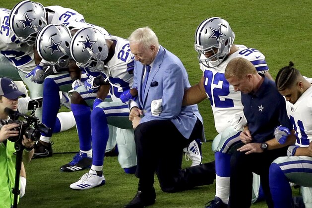 FILE - In this Monday, Sept. 25, 2017, file photo, the Dallas Cowboys, led by owner Jerry Jones, center, take a knee prior to the national anthem and an NFL football game against the Arizona Cardinals, in Glendale, Ariz. ESPN anchor Jemele Hill has been suspended by the network for two weeks for making political statements on social media.  Hill, who is African-American, received criticism from the network last month after referring to President Donald Trump as a