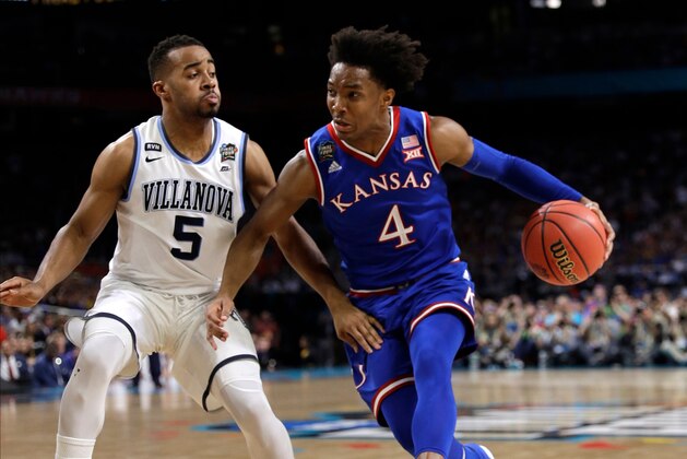 Kansas guard Devonte' Graham (4) drives past Villanova guard Phil Booth during the first half in the semifinals of the Final Four NCAA college basketball tournament, Saturday, March 31, 2018, in San Antonio. (AP Photo/David J. Phillip)