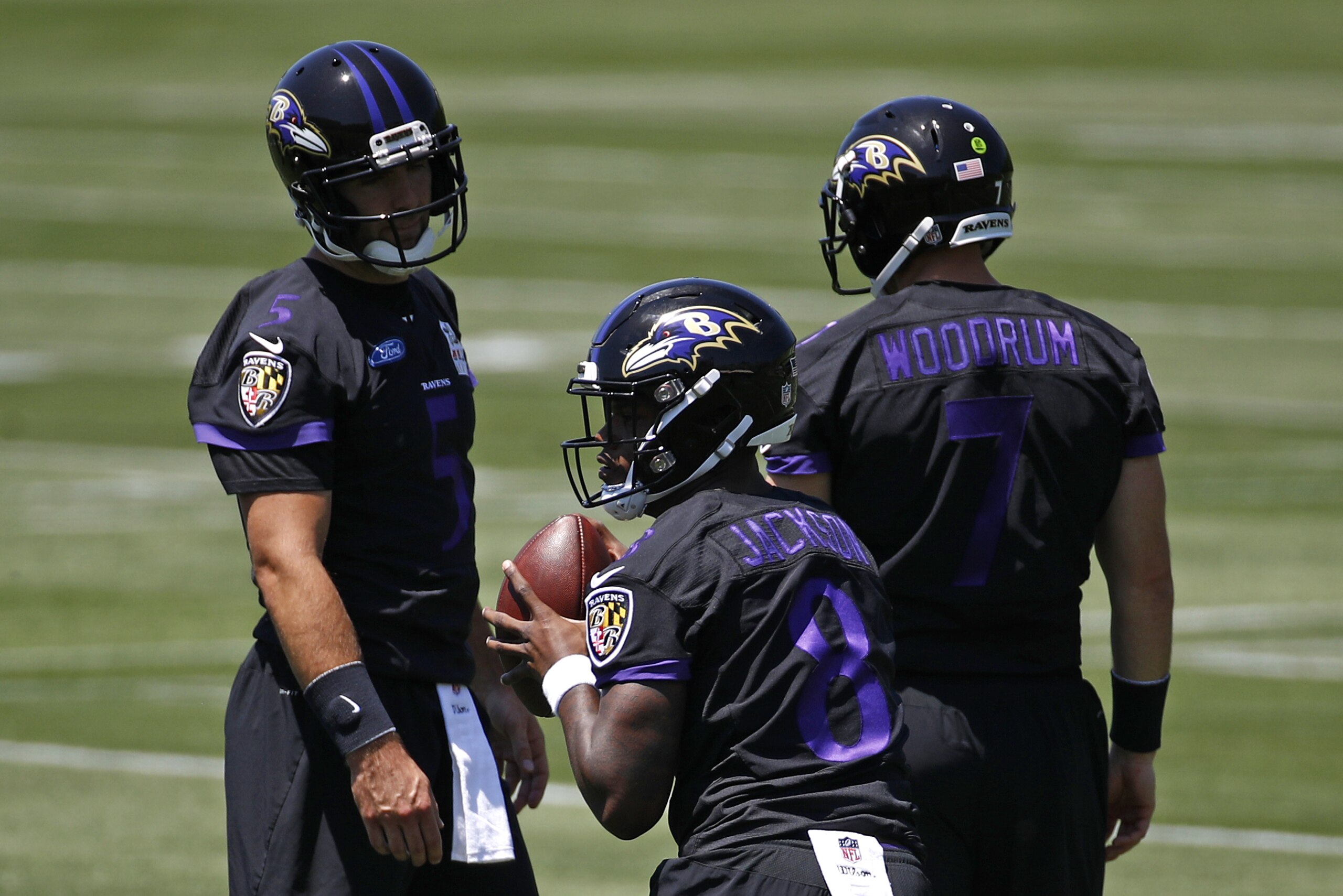 Baltimore Ravens quarterback Lamar Jackson, center, runs a drill in front of quarterbacks Joe Flacco, back left, and Josh Woodrum during an NFL football organized team activity at the team's headquarters in Owings Mills, Md., Thursday, May 24, 2018. (AP Photo/Patrick Semansky)