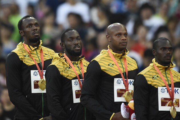 (L-R) Jamaica's gold medal winning team Usain Bolt, Nickel Ashmeade, Asafa Powell and Nesta Carter attend the victory ceremony for the men's 4x100 metres relay athletics event at the 2015 IAAF World Championships at the 'Bird's Nest' National Stadium in Beijing on August 30, 2015.  AFP PHOTO / FRANCK FIFE        (Photo credit should read FRANCK FIFE/AFP/Getty Images)