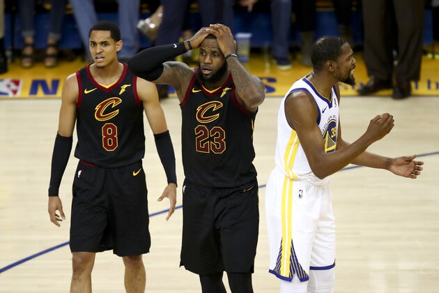 Cleveland Cavaliers forward LeBron James (23) reacts between guard Jordan Clarkson (8) and Golden State Warriors forward Kevin Durant during the second half of Game 1 of basketball's NBA Finals in Oakland, Calif., Thursday, May 31, 2018. (AP Photo/Ben Margot)