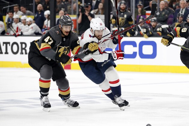 Vegas Golden Knights defenseman Luca Sbisa, of Italy, and Washington Capitals center Chandler Stephenson skate to the puck during the first period in Game 2 of the NHL hockey Stanley Cup Finals on Wednesday, May 30, 2018, in Las Vegas. (AP Photo/John Locher)