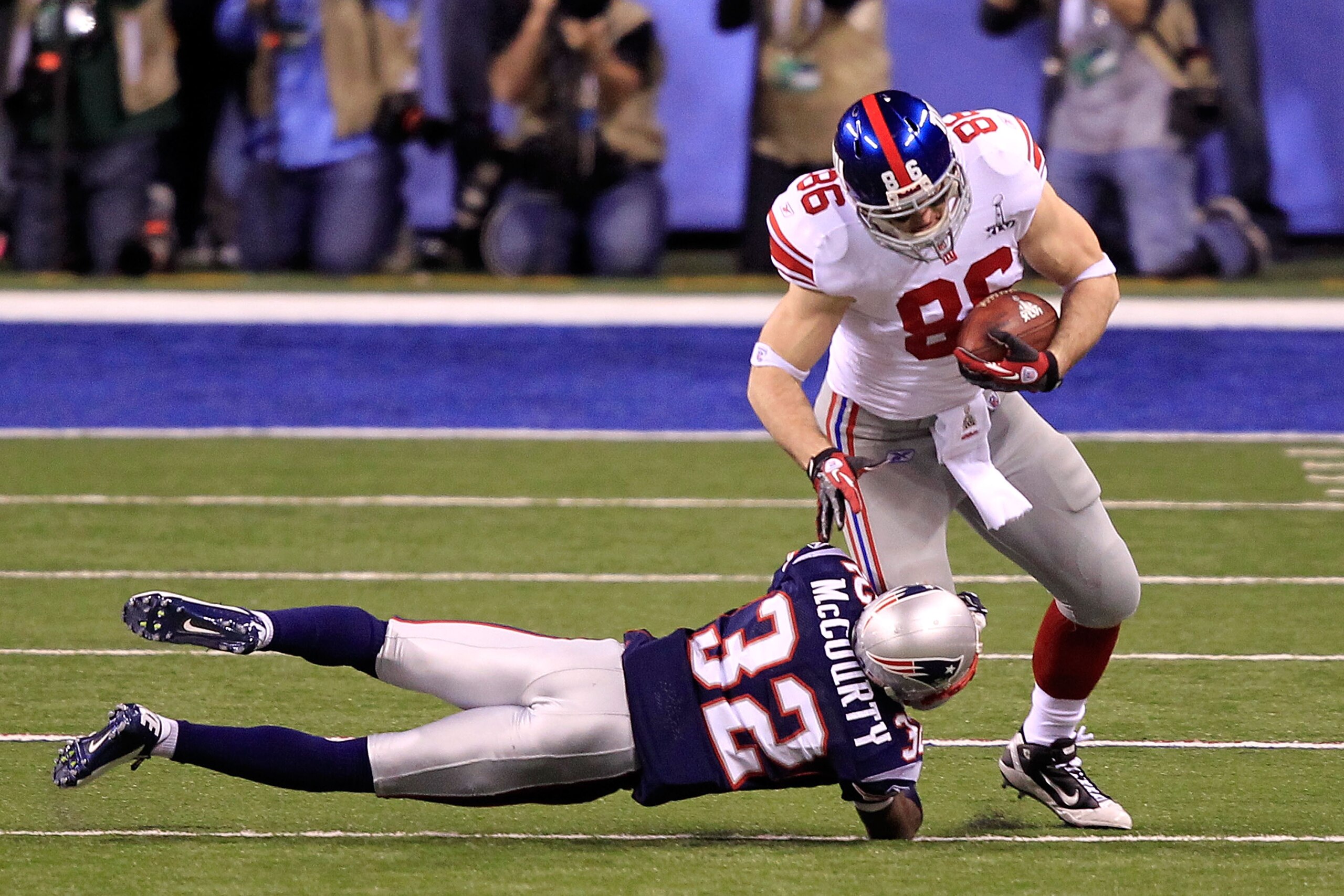 INDIANAPOLIS, IN - FEBRUARY 05:  Tight end Bear Pascoe #86 of the New York Giants runs with the ball after a catch Eli Manning #10 in the first quarter against Devin McCourty #32 of the New England Patriots during Super Bowl XLVI at Lucas Oil Stadium on February 5, 2012 in Indianapolis, Indiana.  (Photo by Chris Trotman/Getty Images)