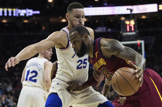 Cleveland Cavaliers' LeBron James, right, drives to the basket against Philadelphia 76ers' Ben Simmons, left, of Australia, during the first half of an NBA basketball game, Friday, April 6, 2018, in Philadelphia. (AP Photo/Chris Szagola)
