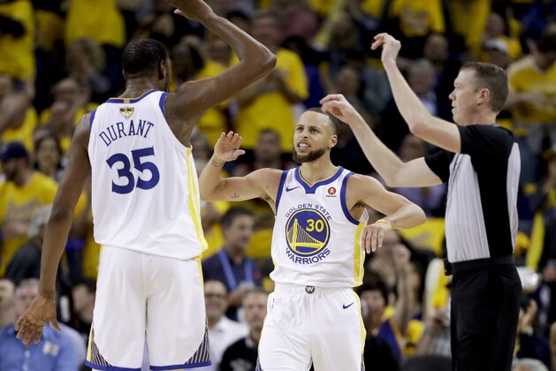 Golden State Warriors forward Kevin Durant (35) celebrates with guard Stephen Curry (30) during the second half of Game 1 of basketball's NBA Finals against the Cleveland Cavaliers in Oakland, Calif., Thursday, May 31, 2018. (AP Photo/Marcio Jose Sanchez)