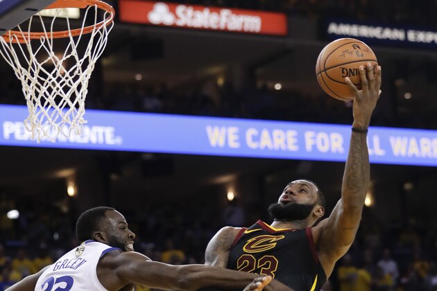 Cleveland Cavaliers forward LeBron James, right, shoots against Golden State Warriors forward Draymond Green during the second half of Game 1 of basketball's NBA Finals in Oakland, Calif., Thursday, May 31, 2018. (AP Photo/Marcio Jose Sanchez)