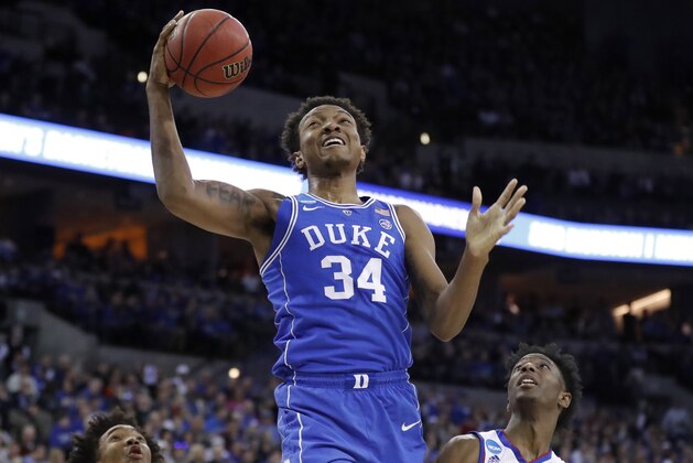 Duke's Wendell Carter Jr (34) heads to the basket as Kansas' Marcus Garrett (0) and Devonte' Graham (4) watch during the first half of a regional final game in the NCAA men's college basketball tournament Sunday, March 25, 2018, in Omaha, Neb. (AP Photo/Charlie Neibergall)