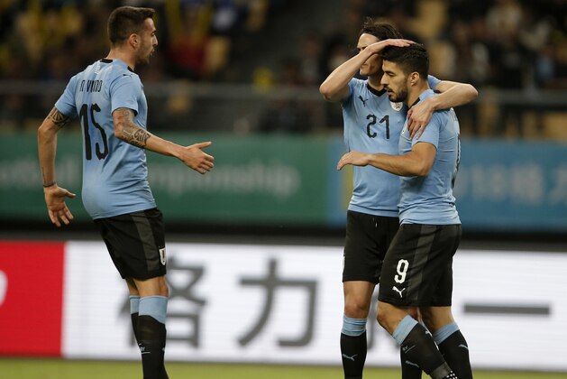 Uruguay's Luis Suarez, right, celebrates with teammates Edinson Cavani, center, and Matias Vecino, left, after scoring a goal against the Czech Republic during their match in the 2018 China Cup International Football Championship in Nanning in southern China's Guangxi province, Friday, March 23, 2018. (Color China Photo via AP)