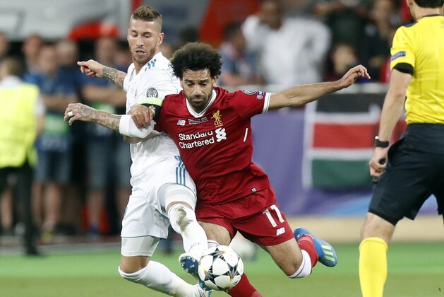 Real Madrid's Sergio Ramos, left, and Liverpool's Mohamed Salah challenge for the ball during the Champions League Final soccer match between Real Madrid and Liverpool at the Olimpiyskiy Stadium in Kiev, Ukraine, Saturday, May 26, 2018. (AP Photo/Efrem Lukatsky)