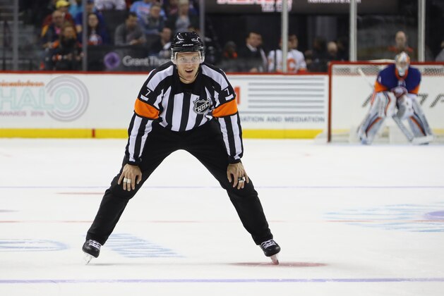 NEW YORK, NY - NOVEMBER 28: Referee Garrett Rank #7 works the game between the New York Islanders and the Calgary Flames at the Barclays Center on November 28, 2016 in the Brooklyn borough of New York City. The Islanders defeated the Flames 2-1 in overtime.  (Photo by Bruce Bennett/Getty Images)