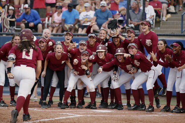 Florida State players wait for Anna Shelnutt (13) at the plate following her solo home run in the sixth inning of the first softball game of the best-of-three championship series against Washington in the NCAA Women's College World Series in Oklahoma City, Monday, June 4, 2018. Florida State won 1-0. (AP Photo/Sue Ogrocki)