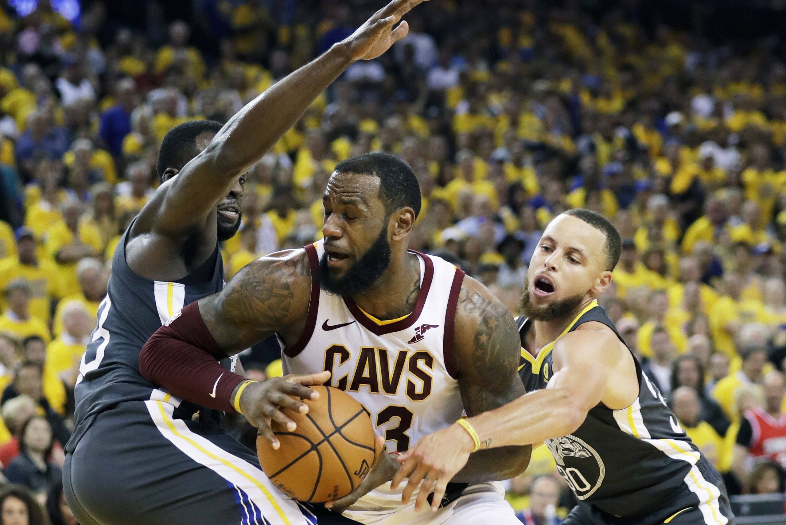 Cleveland Cavaliers forward LeBron James, center, is defended by Golden State Warriors forward Draymond Green, left, and guard Stephen Curry during the second half of Game 2 of basketball's NBA Finals in Oakland, Calif., Sunday, June 3, 2018. (AP Photo/Marcio Jose Sanchez) Cleveland Cavaliers forward LeBron James, center, is defended by Golden State Warriors forward Draymond Green, left, and guard Stephen Curry during the second half of Game 2 of basketball's NBA Finals in Oakland, Calif., Sunday, June 3, 2018. (AP Photo/Marcio Jose Sanchez)