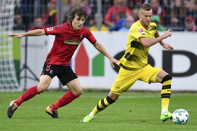 Freiburg's Turkish defender Caglar Soyuncu (L) and Dortmund's Ukrainian forward Andrey Yarmolenko vie for the ball during German first division Bundesliga football match between SC Freiburg and Borussia Dortmund on September 9, 2017 in Freiburg, southwestern Germany. / AFP PHOTO / THOMAS KIENZLE / RESTRICTIONS: DURING MATCH TIME: DFL RULES TO LIMIT THE ONLINE USAGE TO 15 PICTURES PER MATCH AND FORBID IMAGE SEQUENCES TO SIMULATE VIDEO. == RESTRICTED TO EDITORIAL USE == FOR FURTHER QUERIES PLEASE CONTACT DFL DIRECTLY AT + 49 69 650050
        (Photo credit should read THOMAS KIENZLE/AFP/Getty Images)