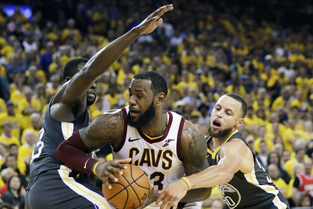 Cleveland Cavaliers forward LeBron James, center, is defended by Golden State Warriors forward Draymond Green, left, and guard Stephen Curry during the second half of Game 2 of basketball's NBA Finals in Oakland, Calif., Sunday, June 3, 2018. (AP Photo/Marcio Jose Sanchez)