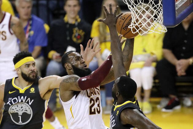 Cleveland Cavaliers forward LeBron James (23) shoots between Golden State Warriors center JaVale McGee (1) and forward Draymond Green during the second half of Game 2 of basketball's NBA Finals in Oakland, Calif., Sunday, June 3, 2018. (AP Photo/Marcio Jose Sanchez)