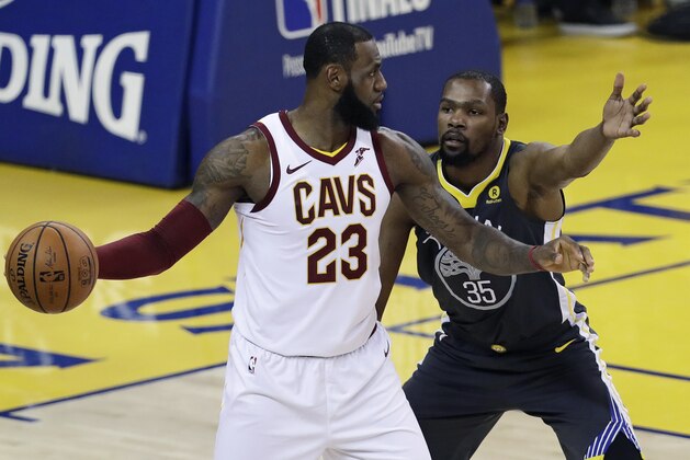 Cleveland Cavaliers forward LeBron James, left, is defended by Golden State Warriors forward Kevin Durant during the first half of Game 2 of basketball's NBA Finals in Oakland, Calif., Sunday, June 3, 2018. (AP Photo/Marcio Jose Sanchez)