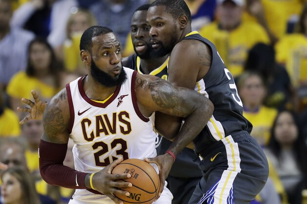 Cleveland Cavaliers forward LeBron James (23) drives against Golden State Warriors forward Draymond Green, center rear, and forward Kevin Durant during the first half of Game 2 of basketball's NBA Finals in Oakland, Calif., Sunday, June 3, 2018. (AP Photo/Marcio Jose Sanchez)
