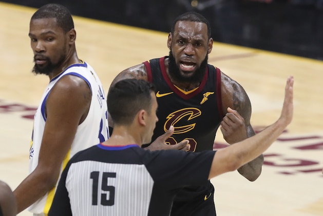 Cleveland Cavaliers' LeBron James argues a call with referee Zach Zarba (15) during the first half against the Golden State Warriors in Game 3 of basketball's NBA Finals, Wednesday, June 6, 2018, in Cleveland. Warriors' Kevin Durant is at left. (AP Photo/Carlos Osorio)