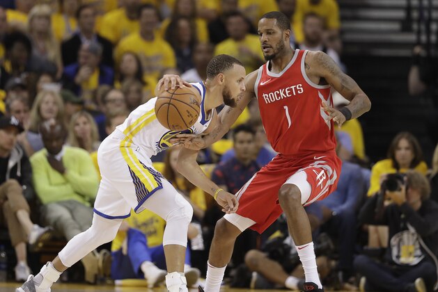 Golden State Warriors guard Stephen Curry, left, dribbles against Houston Rockets forward Trevor Ariza (1) during the first half of Game 3 of the NBA basketball Western Conference Finals in Oakland, Calif., Sunday, May 20, 2018. (AP Photo/Marcio Jose Sanchez)