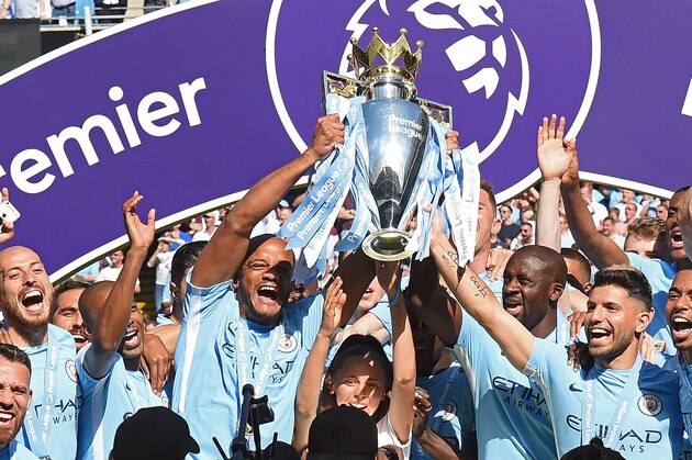 Manchester City's captain, Belgian defender Vincent Kompany (centre left) and Manchester City's Argentinian striker Sergio Aguero (R) lift up the Premier League trophy as they celebrate on the pitch after the English Premier League football match between Manchester City and Huddersfield Town at the Etihad Stadium in Manchester, north west England, on May 6, 2018. (Photo by Paul ELLIS / AFP) / RESTRICTED TO EDITORIAL USE. No use with unauthorized audio, video, data, fixture lists, club/league logos or 'live' services. Online in-match use limited to 75 images, no video emulation. No use in betting, games or single club/league/player publications. /         (Photo credit should read PAUL ELLIS/AFP/Getty Images)