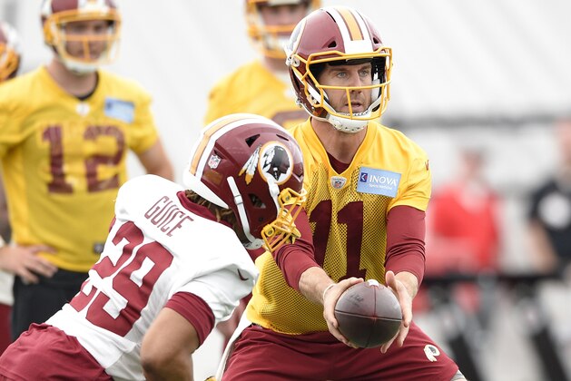 Washington Redskins quarterback Alex Smith (11) hands off to running back Derrius Guice (29) during an NFL football team practice, Wednesday, May 23, 2018, in Ashburn, Va. (AP Photo/Nick Wass)