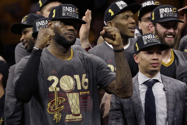 Cleveland Cavaliers forward LeBron James, left, celebrates with head coach Tyronn Lue, right, and teammates after Game 7 of basketball's NBA Finals against the Golden State Warriors in Oakland, Calif., Sunday, June 19, 2016. The Cavaliers won 93-89. (AP Photo/Marcio Jose Sanchez)