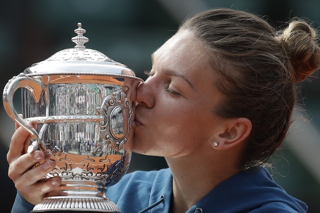 Romania's Simona Halep kisses the trophy as she celebrates winning the final match of the French Open tennis tournament against Sloane Stephens of the U.S. in three sets 3-6, 6-4, 6-1, at the Roland Garros stadium in Paris, France, Saturday, June 9, 2018. (AP Photo/Alessandra Tarantino)