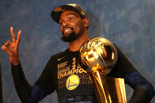CLEVELAND,OH - Kevin Durant #35 of the Golden State Warriors poses for a portrait with the Larry O'Brien Championship trophy after defeating the Cleveland Cavaliers in Game Four of the 2018 NBA Finals on June 8, 2018 at Quicken Loans Arena in Cleveland, Ohio. NOTE TO USER: User expressly acknowledges and agrees that, by downloading and/or using this photograph, user is consenting to the terms and conditions of the Getty Images License Agreement. Mandatory Copyright Notice: Copyright 2018 NBAE (Photo by Joe Murphy/NBAE via Getty Images)